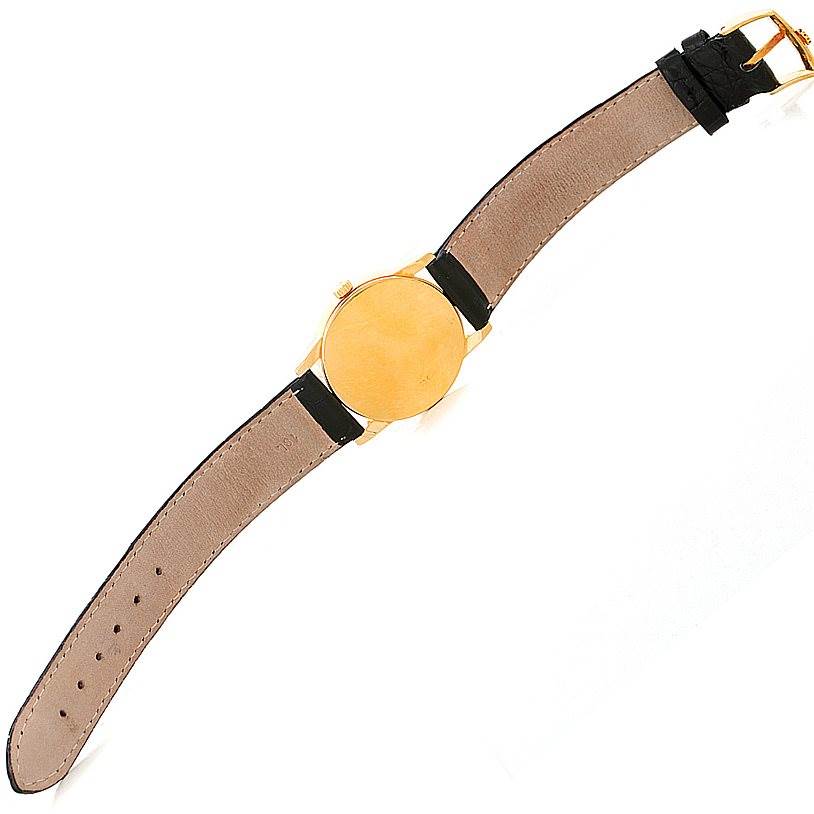 This image shows a top-down view of a Rolex Cellini 5116 Men's Yellow Gold Grey Dial 5116 Men's Yellow Gold Grey Dial watch featuring its gold case and leather strap.