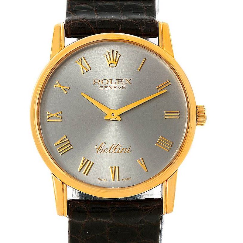 The Rolex Cellini watch is shown from a front angle, displaying its face, crown, hands, and leather strap.