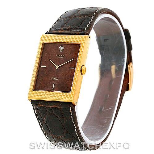 The image shows a Rolex Cellini 4127 Men
s Yellow Gold Brown Dial 4127 Men
s Yellow Gold Brown Dial watch from an angled side view, highlighting its rectangular face and brown leather strap.