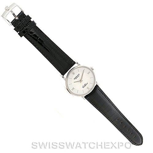 The image shows a top-down view of a Rolex Cellini 5115 Men's White Gold Silver Dial 5115 Men's White Gold Silver Dial watch, highlighting its black leather strap and the face of the watch.