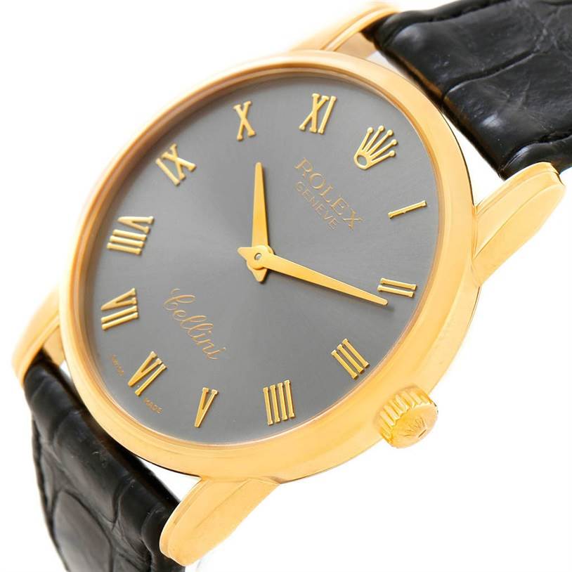 The image shows a close-up angle of a Rolex Cellini 5116 Men's Yellow Gold Grey Dial 5116 Men's Yellow Gold Grey Dial watch, highlighting its gold case, grey dial, Roman numerals, and leather strap.