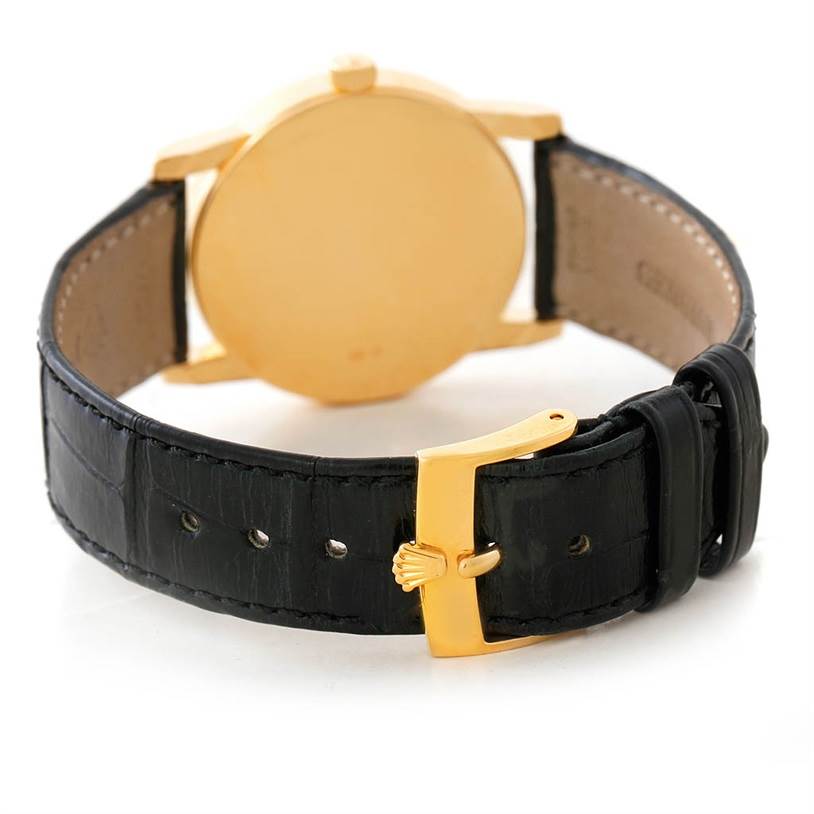 The image shows the rear view of a Rolex Cellini 5116 Men's Yellow Gold Grey Dial 5116 Men's Yellow Gold Grey Dial watch, highlighting the gold case and black leather strap with a gold buckle.