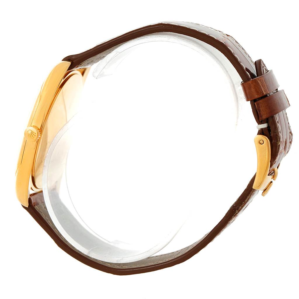 The image shows a side view of the Rolex Cellini 4233 Men's Yellow Gold Black Dial 4233 Men's Yellow Gold Black Dial watch, highlighting the crown, gold case, and brown leather strap with clasp.