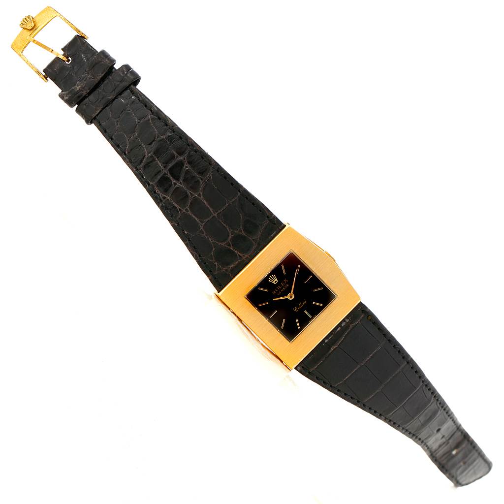 This image shows a top-down view of a Rolex Cellini 4017 Men's Yellow Gold Black Dial 4017 Men's Yellow Gold Black Dial watch, displaying its square face, gold case, and black leather strap.