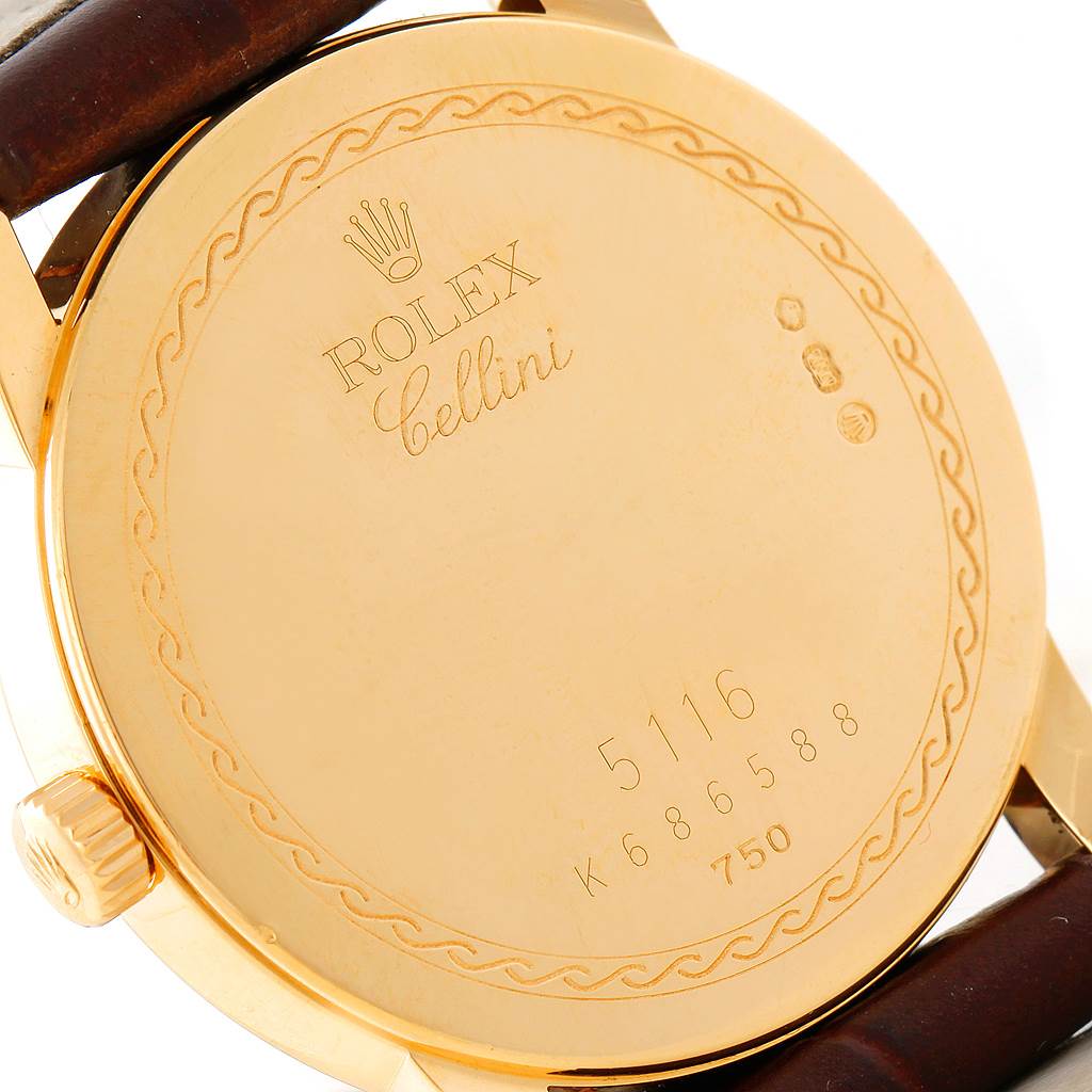 The image shows the backside of a Rolex Cellini 5116 Men's Yellow Gold Beige Dial 5116 Men's Yellow Gold Beige Dial watch, displaying engravings and part of the leather strap.