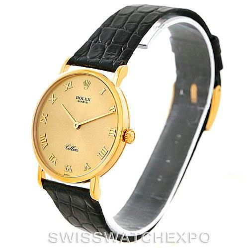 The image shows a Rolex Cellini 5112 Men
s Yellow Gold Champagne Dial 5112 Men
s Yellow Gold Champagne Dial model watch at an angled side view, highlighting its gold case, black leather strap, and Roman numeral dial.