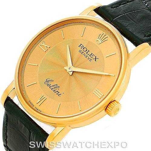 The image shows a close-up view of a Rolex Cellini 5115 Men
s Yellow Gold Champagne Dial 5115 Men
s Yellow Gold Champagne Dial watch, highlighting its golden dial and black leather strap.