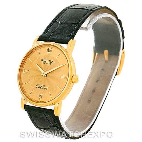 This image shows a Rolex Cellini 5115 Men
s Yellow Gold Champagne Dial 5115 Men
s Yellow Gold Champagne Dial watch from an angled side view, highlighting its gold case, Roman numeral dial, and black leather strap.