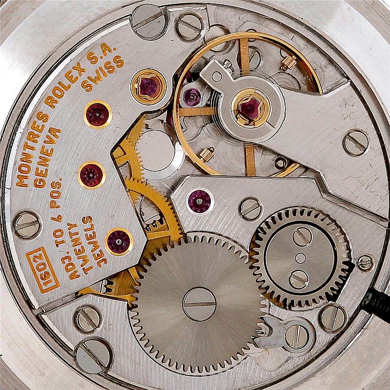 This image shows the intricate internal mechanism of a Rolex Cellini 5112 Men's Yellow Gold Beige Dial 5112 Men's Yellow Gold Beige Dial watch with gears and jeweled pivot points.