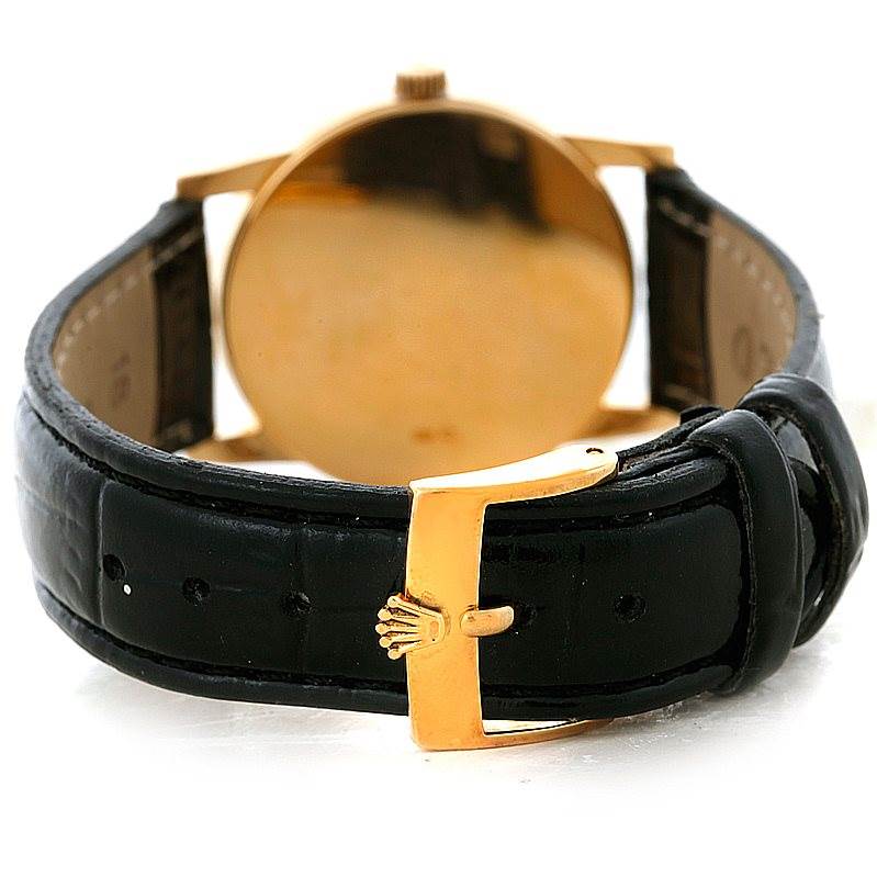The image shows the back view of a Rolex Cellini 5116 Men's Yellow Gold Silver Dial 5116 Men's Yellow Gold Silver Dial watch focusing on its black leather strap and gold buckle.