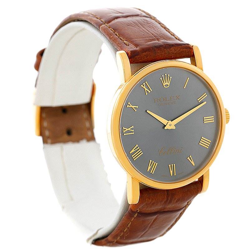 The Rolex Cellini 5115 Men's Yellow Gold Grey Dial 5115 Men's Yellow Gold Grey Dial watch is shown from a three-quarter angle displaying its face, brown leather strap, and gold casing.