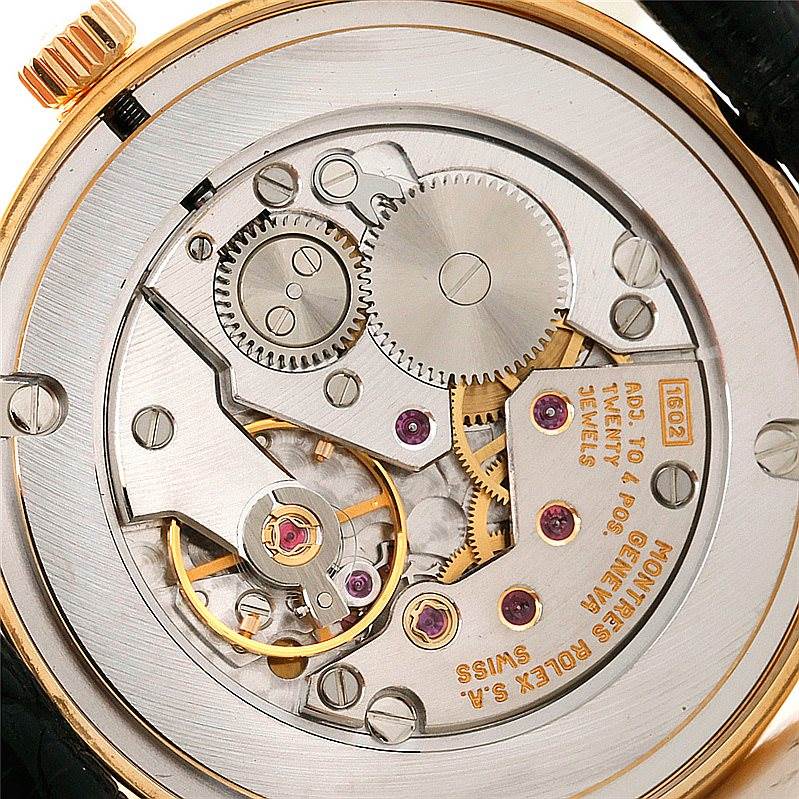 This close-up shot of the Rolex Cellini 5116 Men's Yellow Gold Mother of Pearl Dial 5116 Men's Yellow Gold Mother of Pearl Dial model showcases the intricate inner mechanical movement and gears.