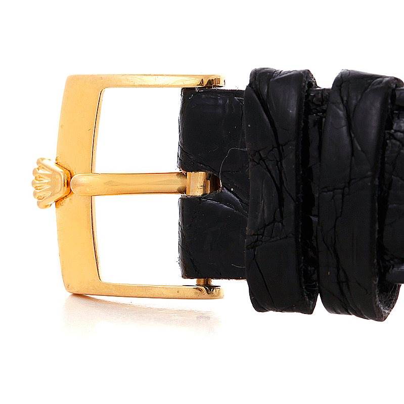 This close-up shows the gold buckle and part of the black leather strap of a Rolex Cellini 5116 Men's Yellow Gold Mother of Pearl Dial 5116 Men's Yellow Gold Mother of Pearl Dial watch.