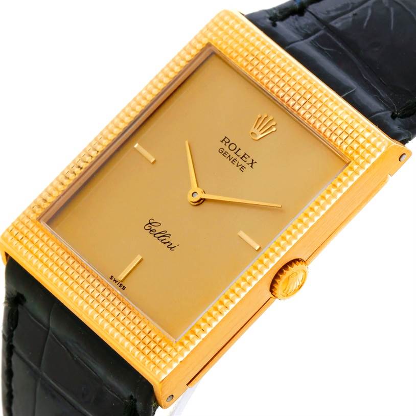 The image shows the front and partial side of a Rolex Cellini 4127 Men
s Yellow Gold Champagne Dial 4127 Men
s Yellow Gold Champagne Dial watch, highlighting its gold rectangular face, textured bezel, and crown.