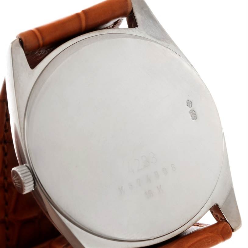 This image shows the back case and part of the leather strap of a Rolex Cellini 4233 Men's White Gold Black Dial 4233 Men's White Gold Black Dial watch.