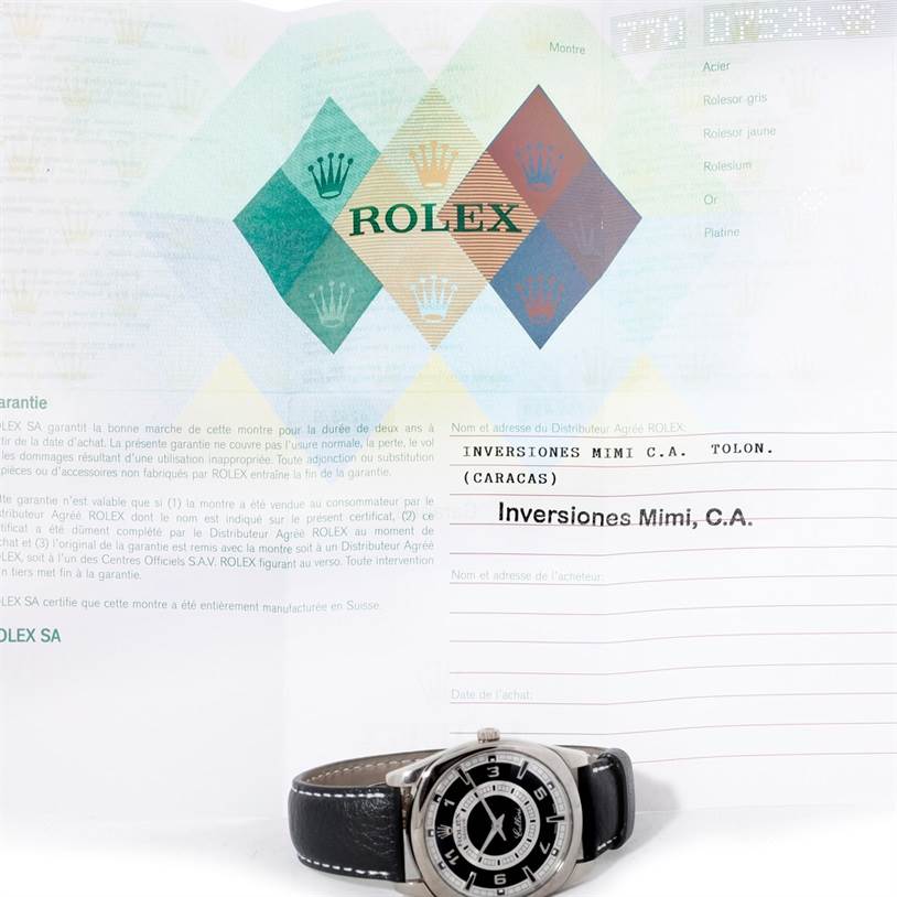 The image shows a Rolex Cellini 4243 Men's White Gold Black Dial 4243 Men's White Gold Black Dial watch placed on a flat surface in front of its warranty and purchase documents.
