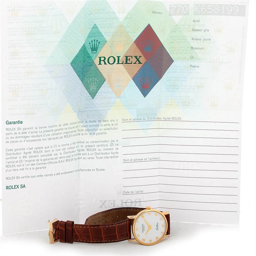 The image shows a Rolex Cellini 5115 Men's Yellow Gold Mother of Pearl Dial 5115 Men's Yellow Gold Mother of Pearl Dial watch at a tilted angle, alongside its warranty and documentation.