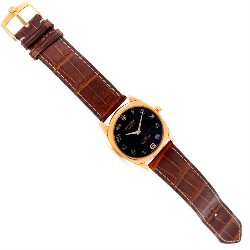 The image shows a top-down view of a Rolex Cellini 4233 Men's Yellow Gold Black Dial 4233 Men's Yellow Gold Black Dial watch featuring a brown leather strap and a gold case with a black dial.