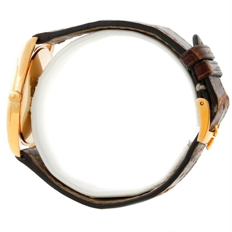 The image shows a side view of a Rolex Cellini 4233 Men's Yellow Gold Black Dial 4233 Men's Yellow Gold Black Dial watch, highlighting the case, crown, leather strap, and buckle.