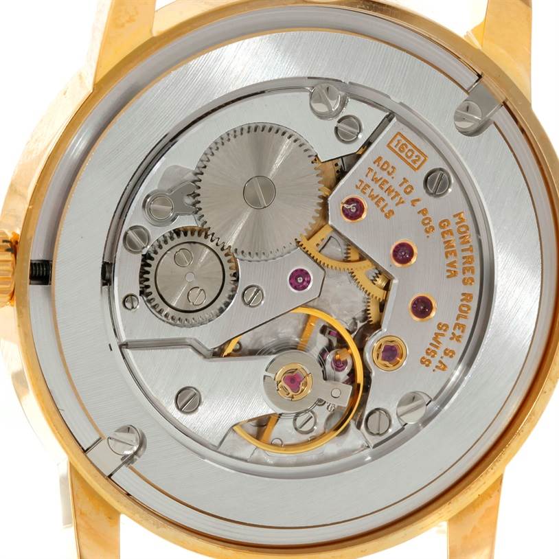 The image shows the intricate movement and internal mechanics of a Rolex Cellini 5116 Men's Yellow Gold Grey Dial 5116 Men's Yellow Gold Grey Dial watch from a rear angle.