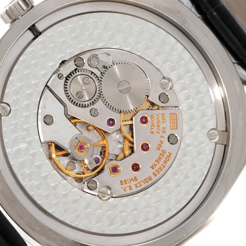 The image shows the back view of a Rolex Cellini 4243 Men's White Gold Black Dial 4243 Men's White Gold Black Dial watch, displaying its intricate mechanical movement and gears.