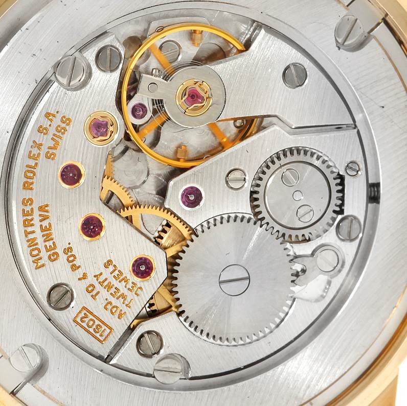 The image shows the intricate internal mechanism of a Rolex Cellini 5116 Men
s Yellow Gold Champagne Dial 5116 Men
s Yellow Gold Champagne Dial watch from a close-up, angled view.