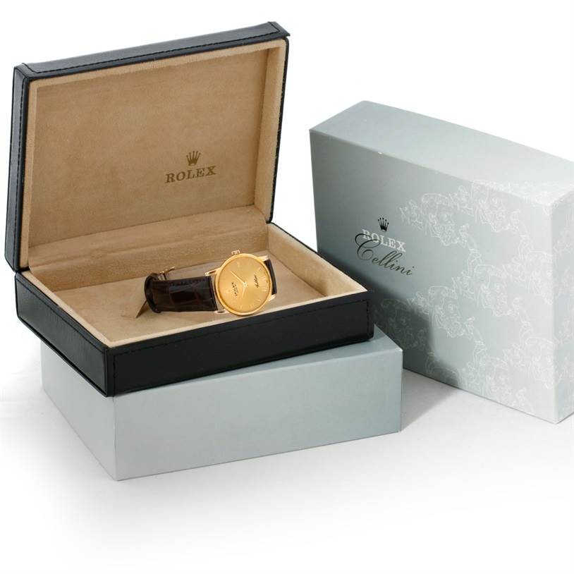 The image shows a Rolex Cellini 5116 Men
s Yellow Gold Champagne Dial 5116 Men
s Yellow Gold Champagne Dial watch in its open black display box, with a closed outer box beside it.