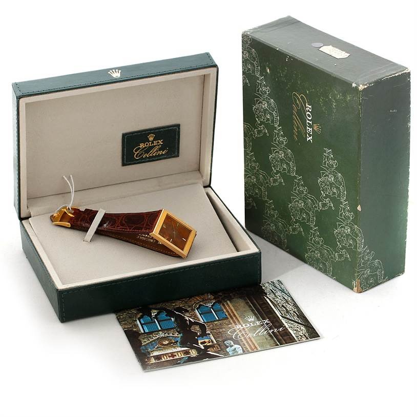 The image shows a Rolex Cellini 4127 Men's Yellow Gold Brown Dial 4127 Men's Yellow Gold Brown Dial watch in its box, along with the external packaging and a booklet, viewed from a slight angle above.