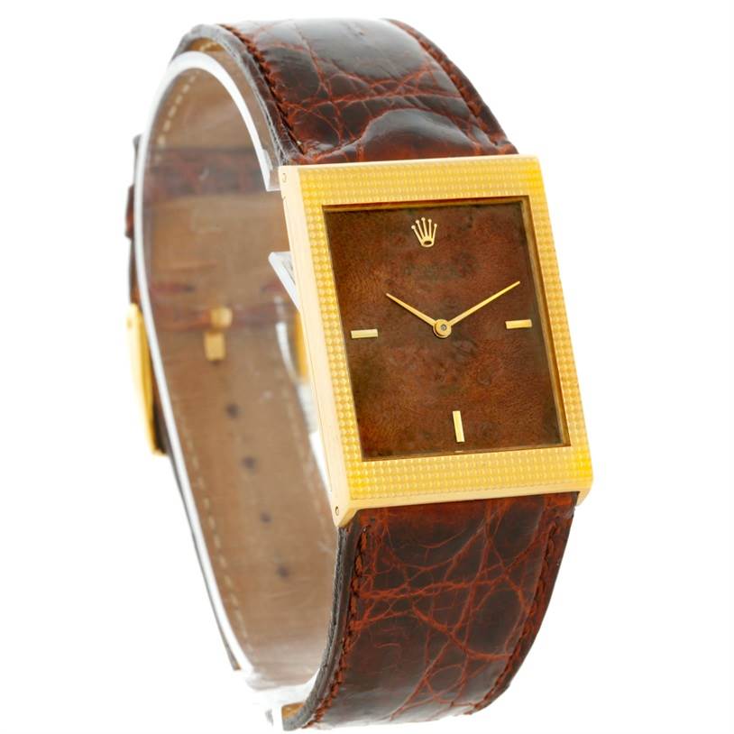 The image shows a side-angle view of a Rolex Cellini 4127 Men's Yellow Gold Brown Dial 4127 Men's Yellow Gold Brown Dial watch, highlighting its leather strap, golden rectangular case, and dial.