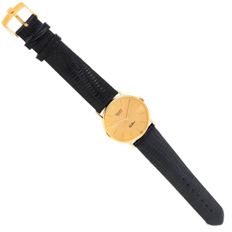 The Rolex Cellini 3833 Men
s Yellow Gold Champagne Dial 3833 Men
s Yellow Gold Champagne Dial watch is shown in a top-down view, featuring its face, black leather strap, and gold buckle.