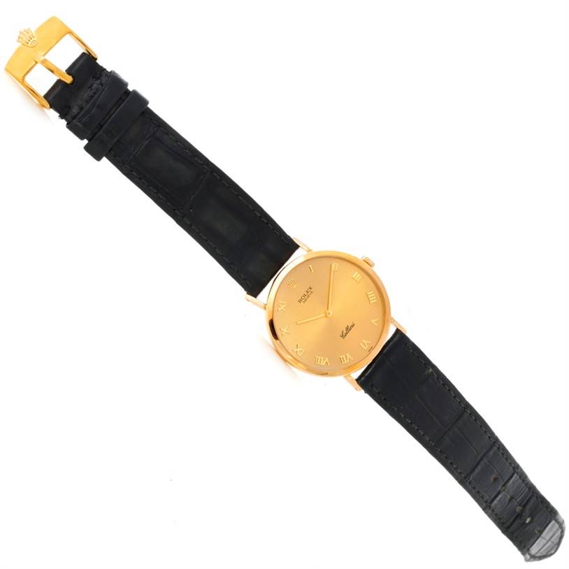 This image shows a top view of a Rolex Cellini 4112 Men
s Yellow Gold Champagne Dial 4112 Men
s Yellow Gold Champagne Dial watch with a gold case and black leather strap.