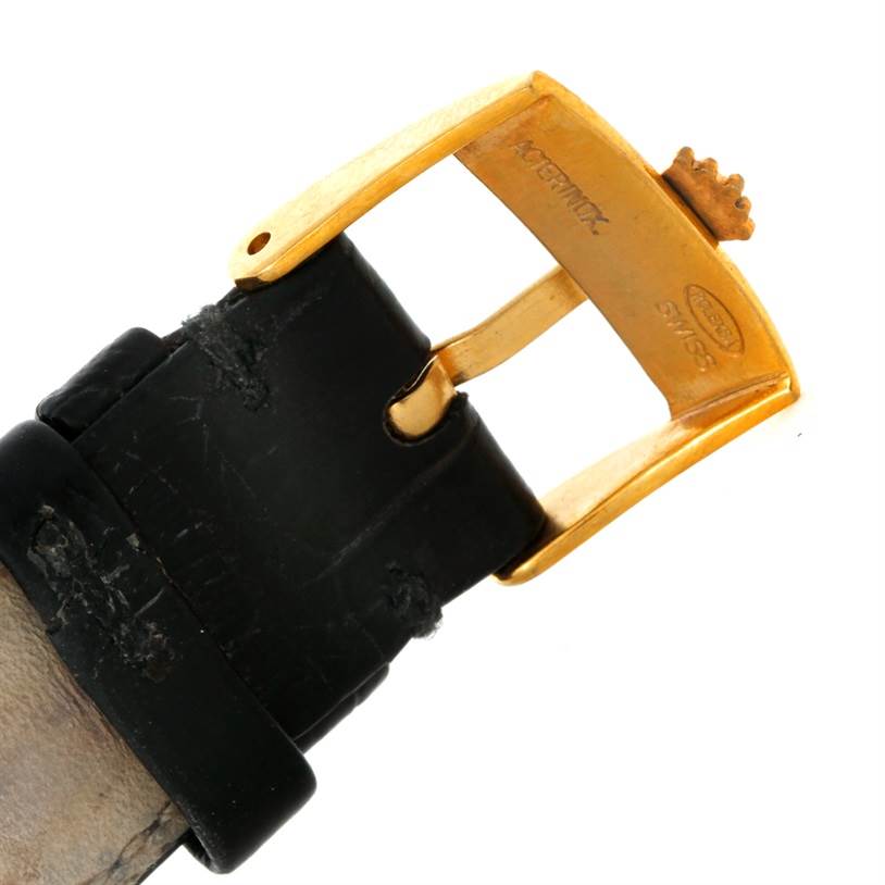 The image shows a close-up of the gold buckle and black leather strap of a Rolex Cellini 4112 Men
s Yellow Gold Champagne Dial 4112 Men
s Yellow Gold Champagne Dial watch.