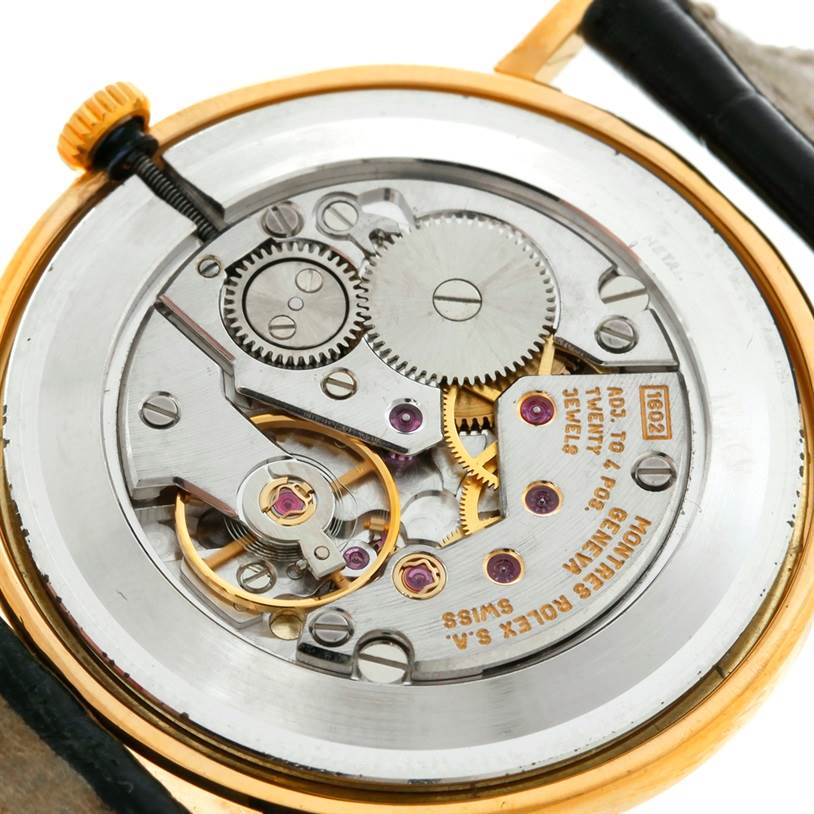 The image shows a close-up view of the movement and inner mechanics of the Rolex Cellini 4112 Men
s Yellow Gold Champagne Dial 4112 Men
s Yellow Gold Champagne Dial watch.