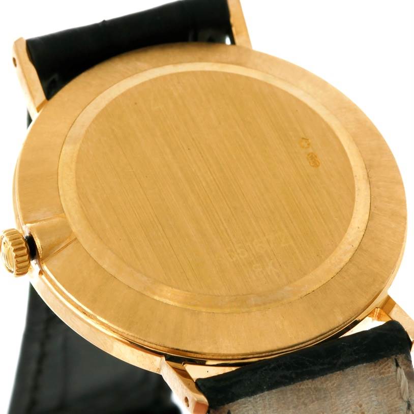 The image shows the back case and crown of a Rolex Cellini 4112 Men
s Yellow Gold Champagne Dial 4112 Men
s Yellow Gold Champagne Dial watch at an angle.