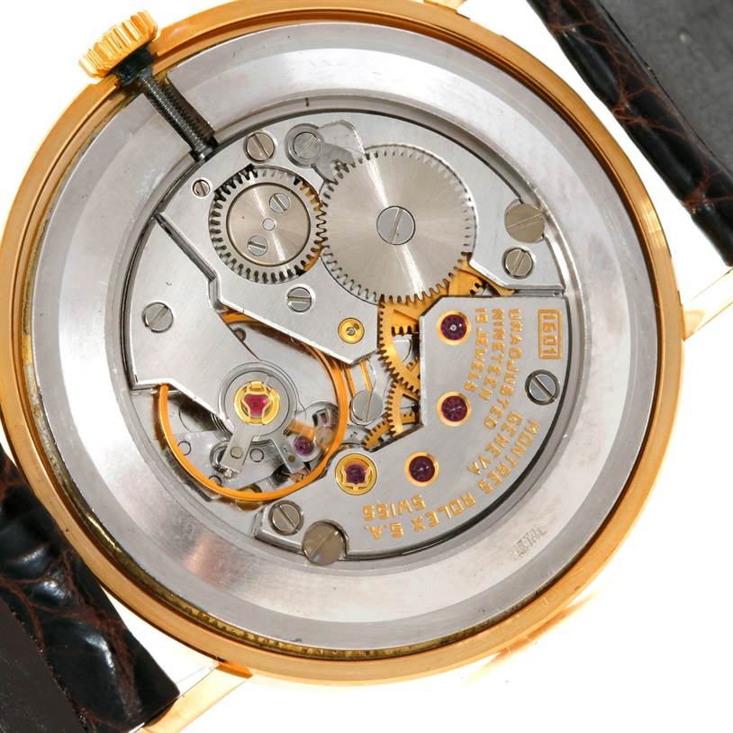This image shows the movement mechanism of a Rolex Cellini 4112 Men
s Yellow Gold Champagne Dial 4112 Men
s Yellow Gold Champagne Dial watch from a back angle, displaying gears and internal components.