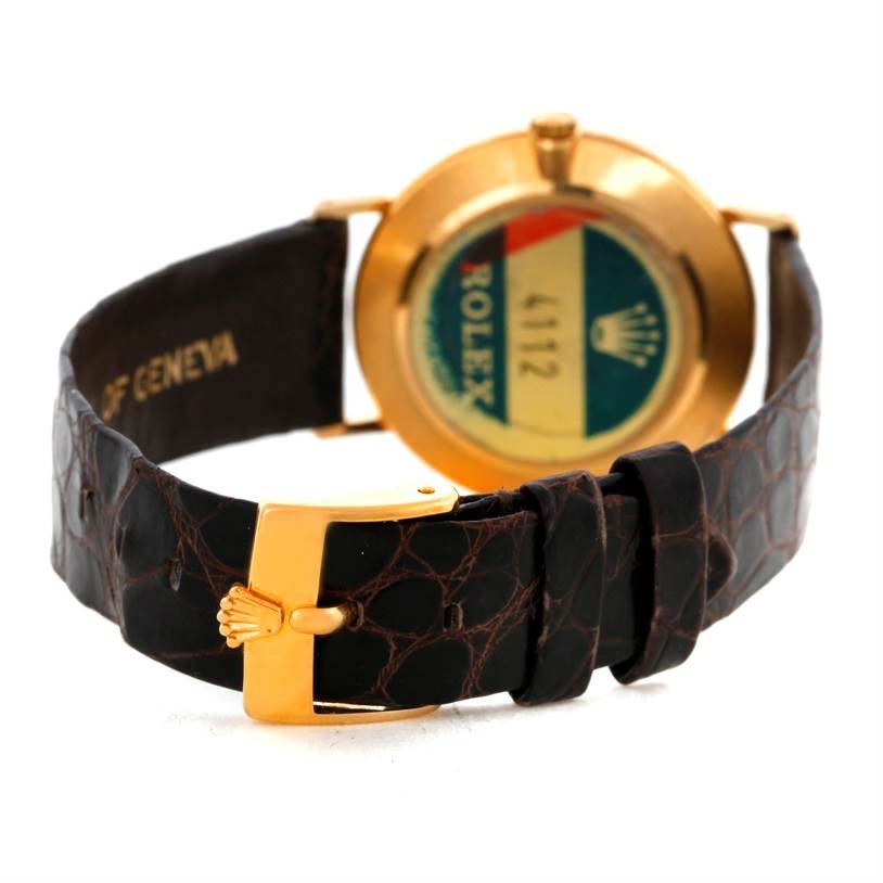 The image shows the back view of a Rolex Cellini 4112 Men
s Yellow Gold Champagne Dial 4112 Men
s Yellow Gold Champagne Dial watch, highlighting its leather strap and buckle with the gold case back visible.