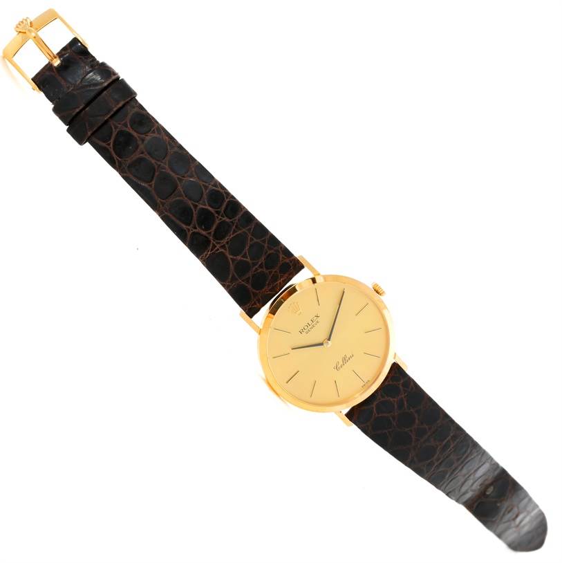 The image shows a Rolex Cellini 4112 Men
s Yellow Gold Champagne Dial 4112 Men
s Yellow Gold Champagne Dial watch from a top-down angle, displaying its dial, strap, and buckle.