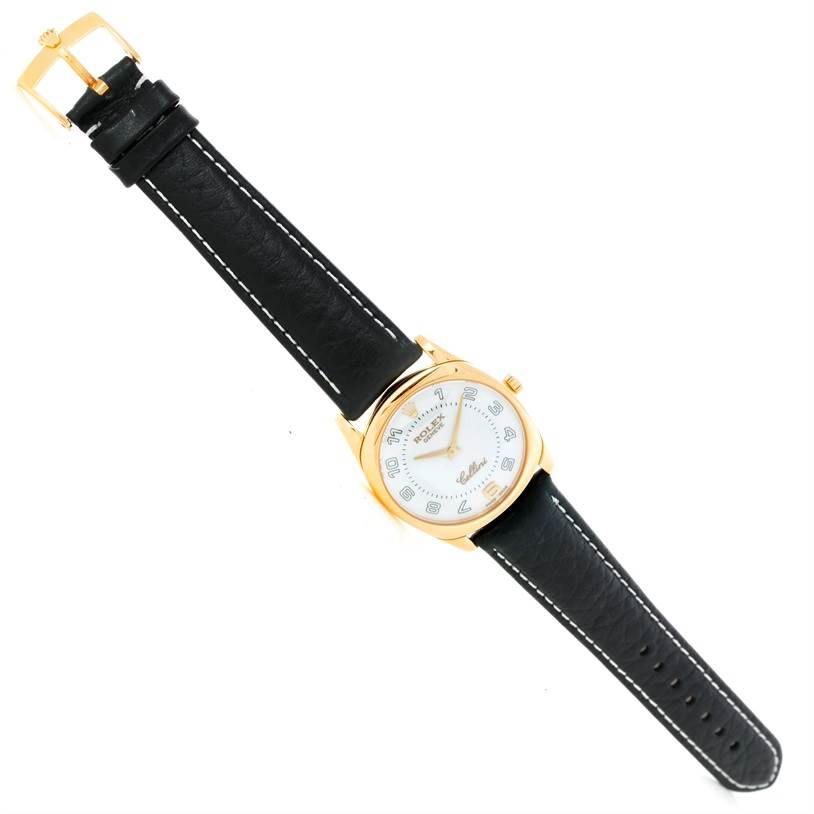 The Rolex Cellini 4233 Men's Yellow Gold Black Dial 4233 Men's Yellow Gold Black Dial watch is shown at a top-down angle, displaying its face, case, and black leather strap.