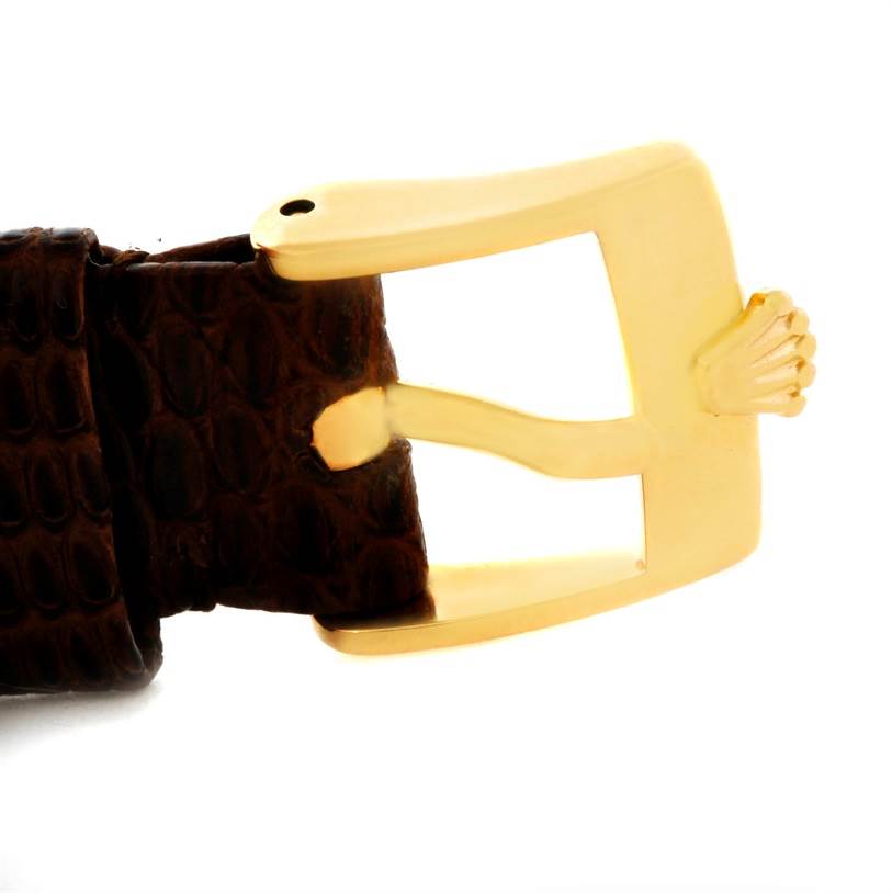 The image shows a close-up of the buckle of a Rolex Cellini 4126 Men's Yellow Gold Champagne Dial 4126 Men's Yellow Gold Champagne Dial watch with a gold clasp and brown leather strap.