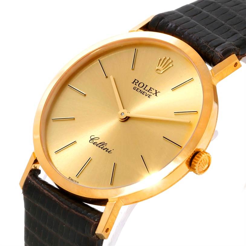 This image shows a close-up of a Rolex Cellini 4112 Yellow Gold Champagne Dial 4112 Yellow Gold Champagne Dial watch face and part of its leather strap, viewed from an oblique angle.