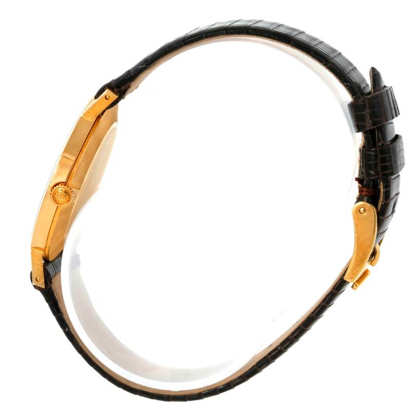 This image shows the side view of a Rolex Cellini 4112 Yellow Gold Champagne Dial 4112 Yellow Gold Champagne Dial watch, highlighting its case, crown, and leather strap.