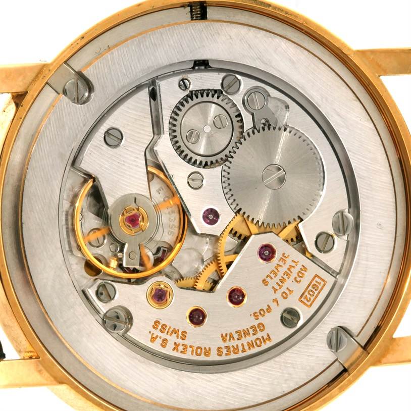 This image shows the internal mechanical movement of a Rolex Cellini 5115 Men
s Yellow Gold Black Dial 5115 Men
s Yellow Gold Black Dial model watch from a rear angle, displaying gears and jewels.