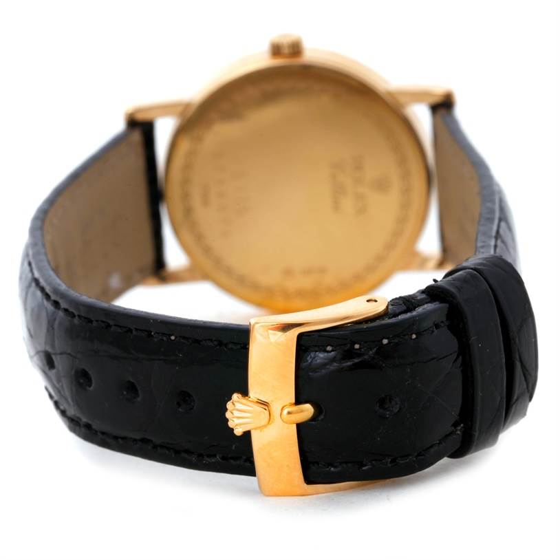 The image shows a rear view of a Rolex Cellini 5115 Men
s Yellow Gold Black Dial 5115 Men
s Yellow Gold Black Dial watch, focusing on the gold case back and black leather strap with a gold buckle.