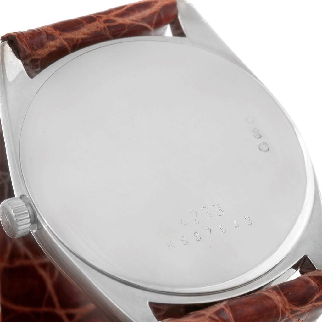 This image shows the back casing and a portion of the leather strap of a Rolex Cellini 4233 Men's White Gold Black Dial 4233 Men's White Gold Black Dial watch at a slight angle.