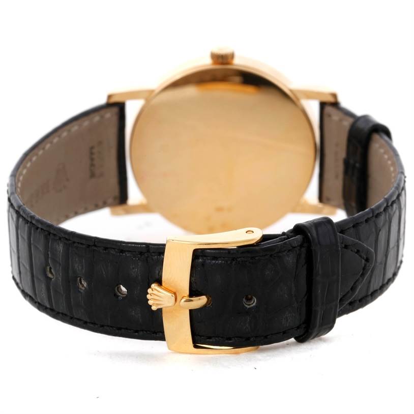 The image shows the back view of a Rolex Cellini 5115 Men's Yellow Gold Black Dial 5115 Men's Yellow Gold Black Dial watch with a black leather strap and a gold buckle.