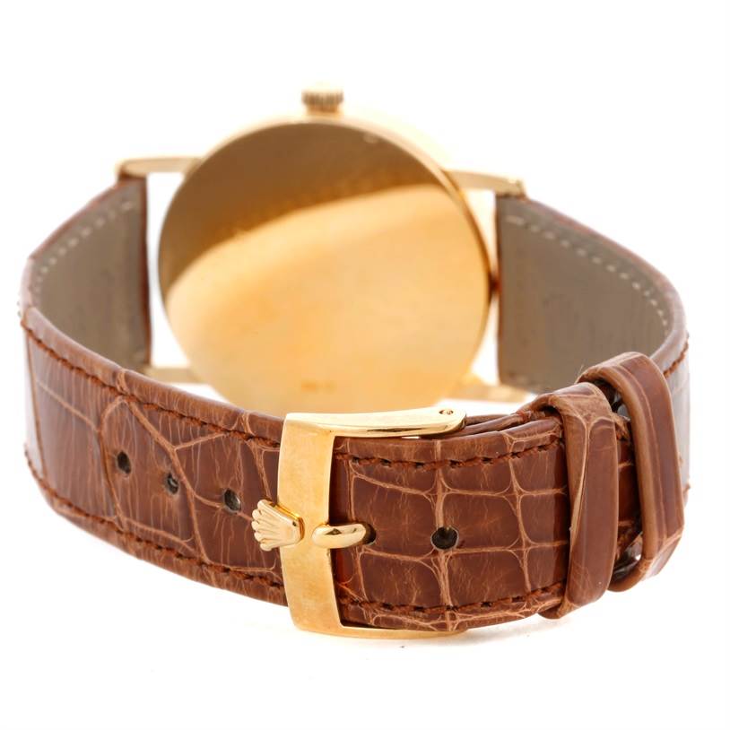 The image shows the back of a Rolex Cellini 5115 Men
s Yellow Gold Mother of Pearl Dial 5115 Men
s Yellow Gold Mother of Pearl Dial watch focusing on its brown leather strap and gold clasp.