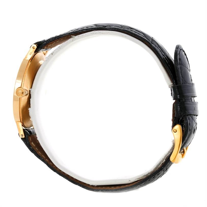 The image shows a Rolex Cellini 5112 Men
s Yellow Gold Champagne Dial 5112 Men
s Yellow Gold Champagne Dial watch from a side angle, highlighting its black leather strap and gold case.