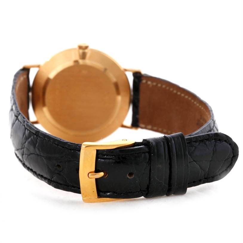 This image shows the back of a Rolex Cellini 5112 Men
s Yellow Gold Champagne Dial 5112 Men
s Yellow Gold Champagne Dial watch featuring its gold case and black leather strap with a gold buckle.