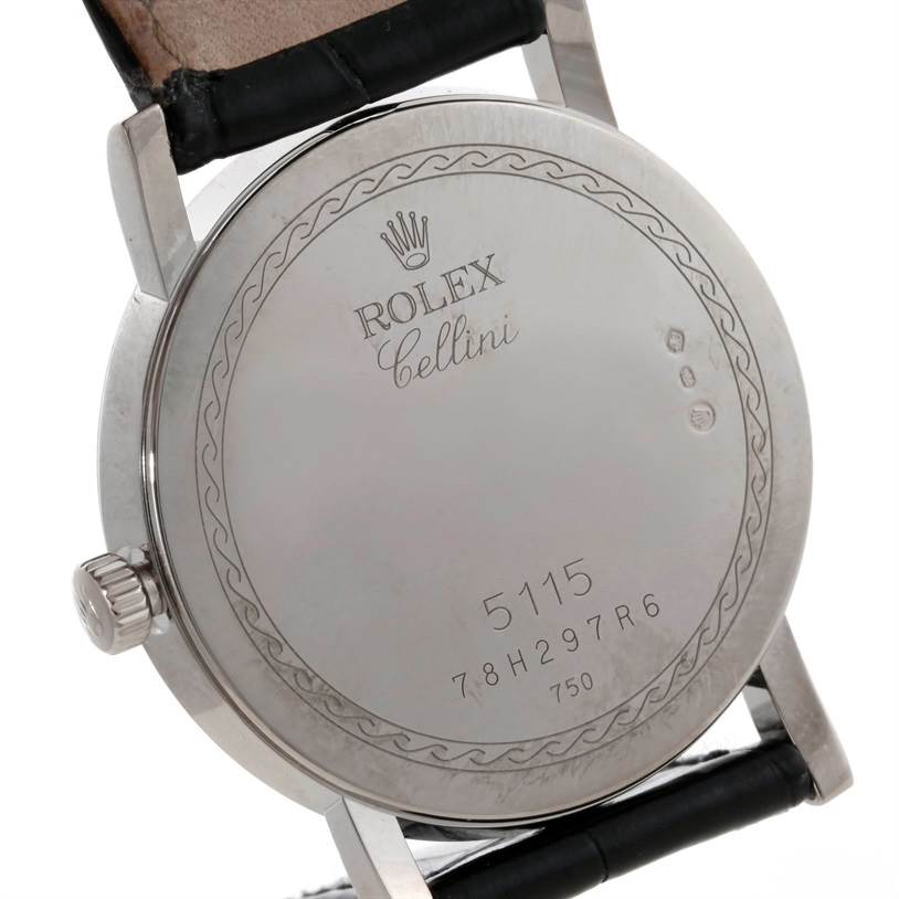 The image shows the back case of a Rolex Cellini 5115 Men
s White Gold Silver Dial 5115 Men
s White Gold Silver Dial watch, highlighting its engravings and black leather strap.