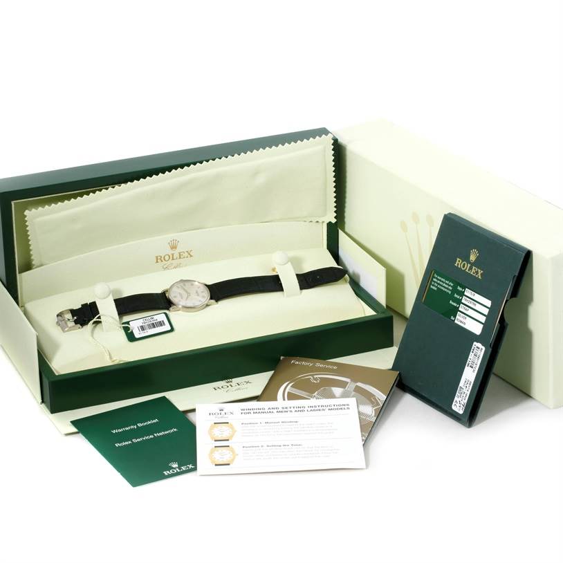 The Rolex Cellini 5115 Men
s White Gold Silver Dial 5115 Men
s White Gold Silver Dial watch is shown inside its box with manuals and warranty cards placed alongside.